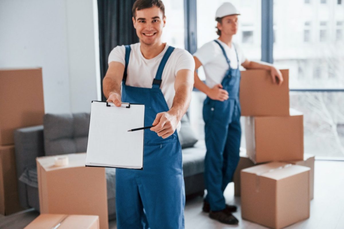 document-to-sign-two-young-movers-in-blue-uniform-working-indoors-in-the-room.jpg